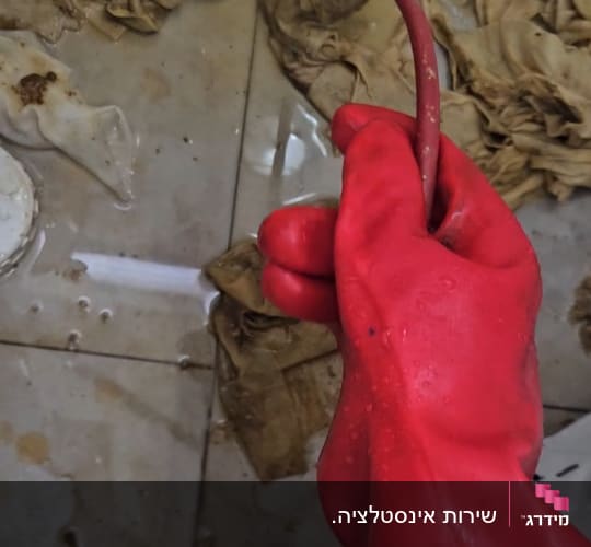 עבודת פתיחת סתימה בצנרת באמצעות ספירלה והוצאת מגבונים מוצפים